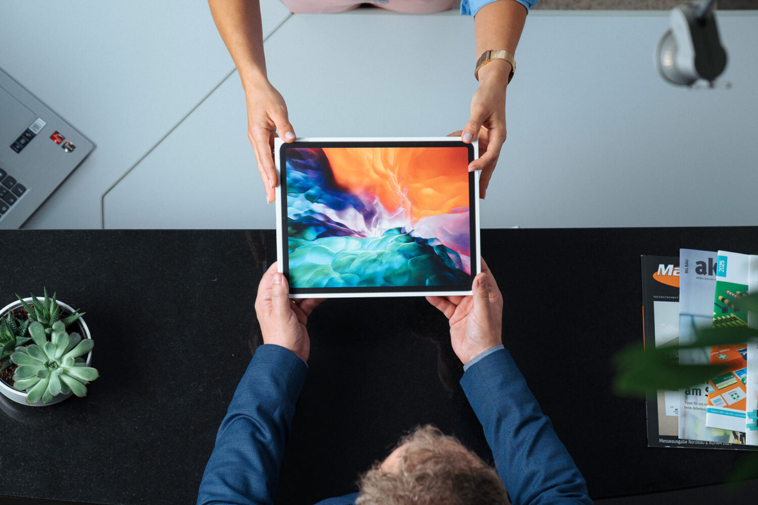 Device Management: Übergabe eines MacBooks durch syniqo Mitarbeiterin